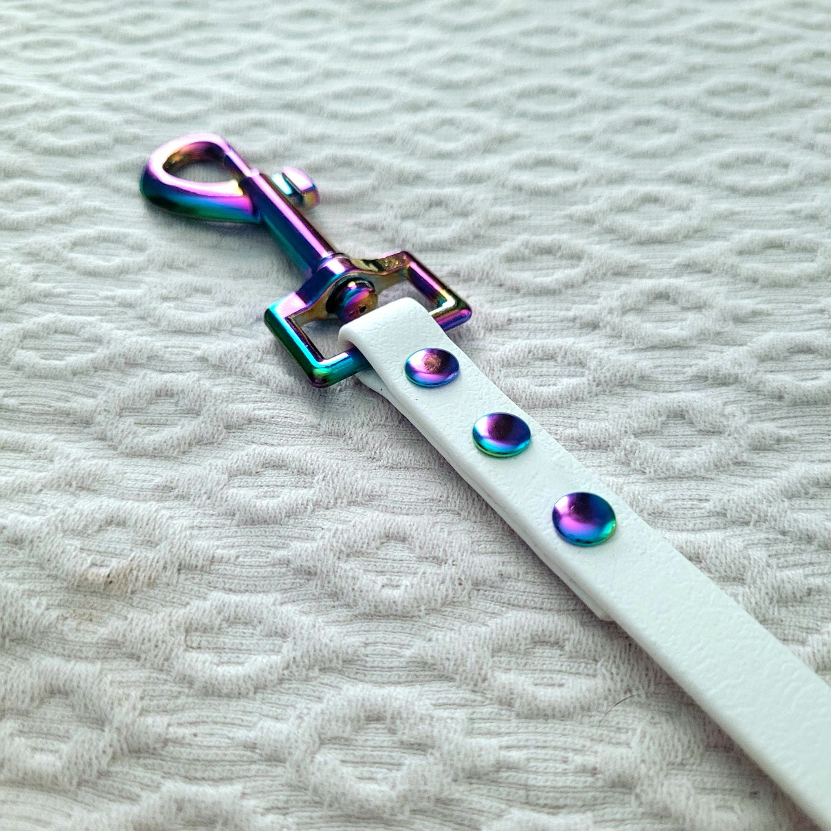 White with rainbow hardware. Clasp is 2.75" long 